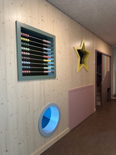Wandgestaltung im Kindergarten mit großem Rechenschieber, Sternöffnung und runden Kriechöffnungen – Schreinerei Hofmann Bamberg